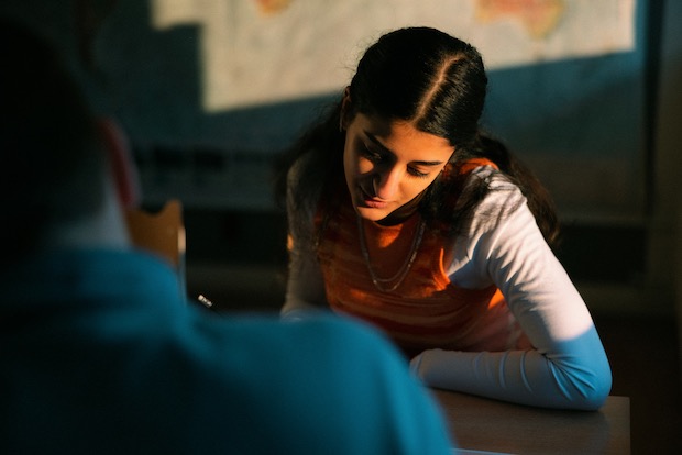 En tjej i ett klassrum som läser någonting. 