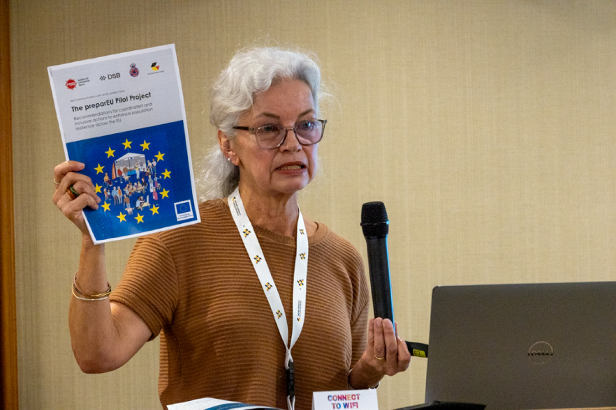 Woman holdning a booklet and a microphone