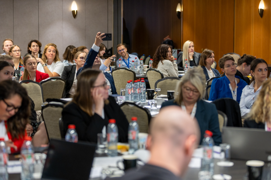 people at a conference sitting behind tables